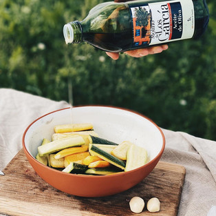 Olīveļļas pudele un dārzeņi