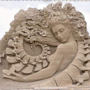 sand sculpture jesolo Italy of a woman and bones shape like a spine and Fibonacci sequence.