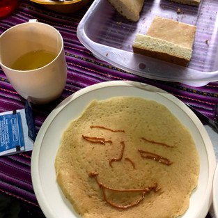 Pancake with a smiley face piped on with chocolate syrup