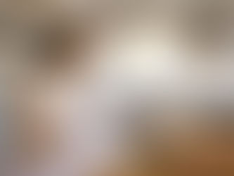 african-american woman in her home sorting bills and paperwork at her laptop