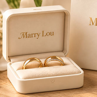 Zwei goldfarbene Trauringe in einer geöffneten Marry Lou Ringschatulle