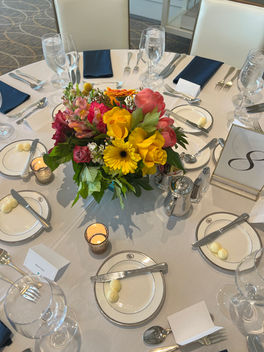 Multicolor spring floral design on a guest table created by Tasha Flowers.