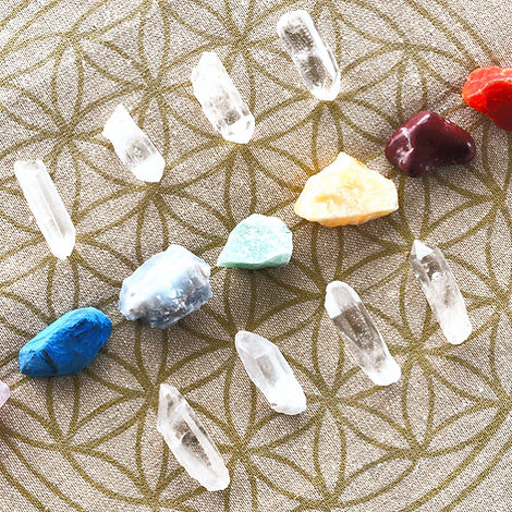 Photo de pierres disposées sur une fleur de vie, symbolisant le nettoyage énergétique et l’alignement des chakras