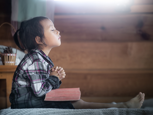 Precious girl praying with BIble.png