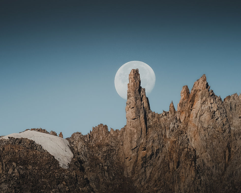 La montagne abrupte se révèle sous la douce lumière de la lune à l'horizon.
