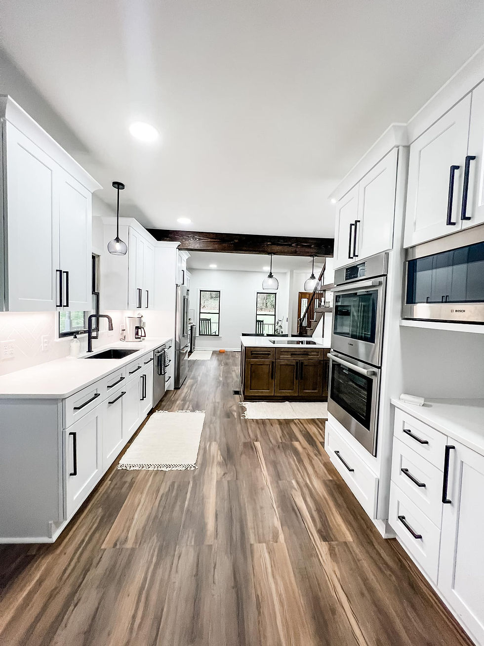 Renovated Kitchen with white cabinetry, stainless appliances, and hardwood floors