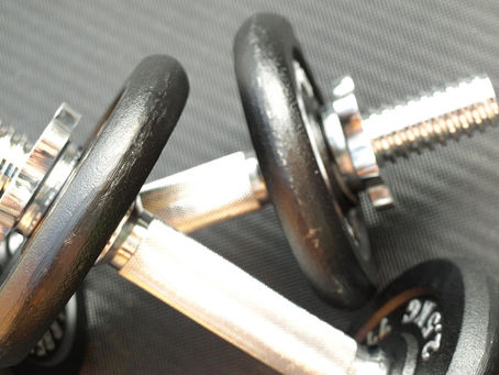 close up image of dumbbells on rubber gym flooring