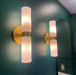 dark green walls with two unique modern sconce light fixtures