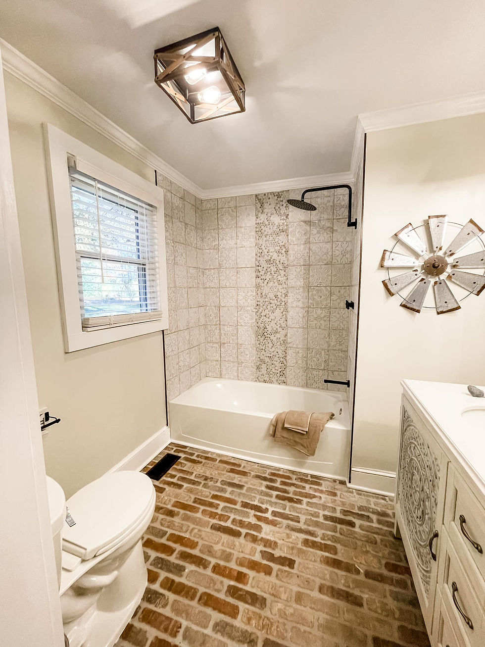 renovated bathroom with brick flooring, tiled shower with rainhead shower head