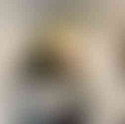 a marble tiled wall behind open dark shelves with a black farmhouse sconce above