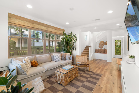 Sun-drenched open-concept living area highlighting wide-plank flooring