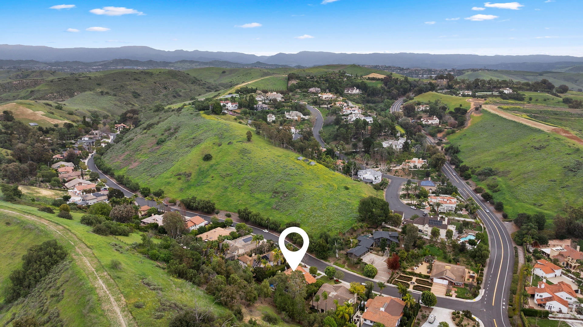 Scenic aerial view highlighting the property's prime location nestled within rolling green hills.