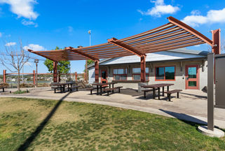 Community pavilion featuring outdoor picnic tables and a modern shade structure.