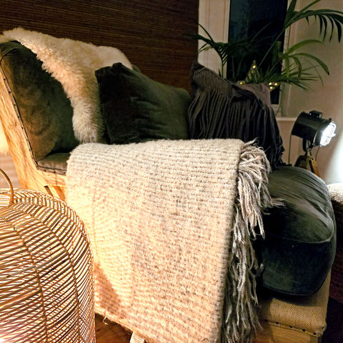 Stylish nook with velvet armchair, textured blankets, and ambient lighting – a relaxing home interior space styled by Design@Studio17