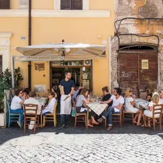 Outdoor seating on a sunny day at Trattoria da Enzo al 29