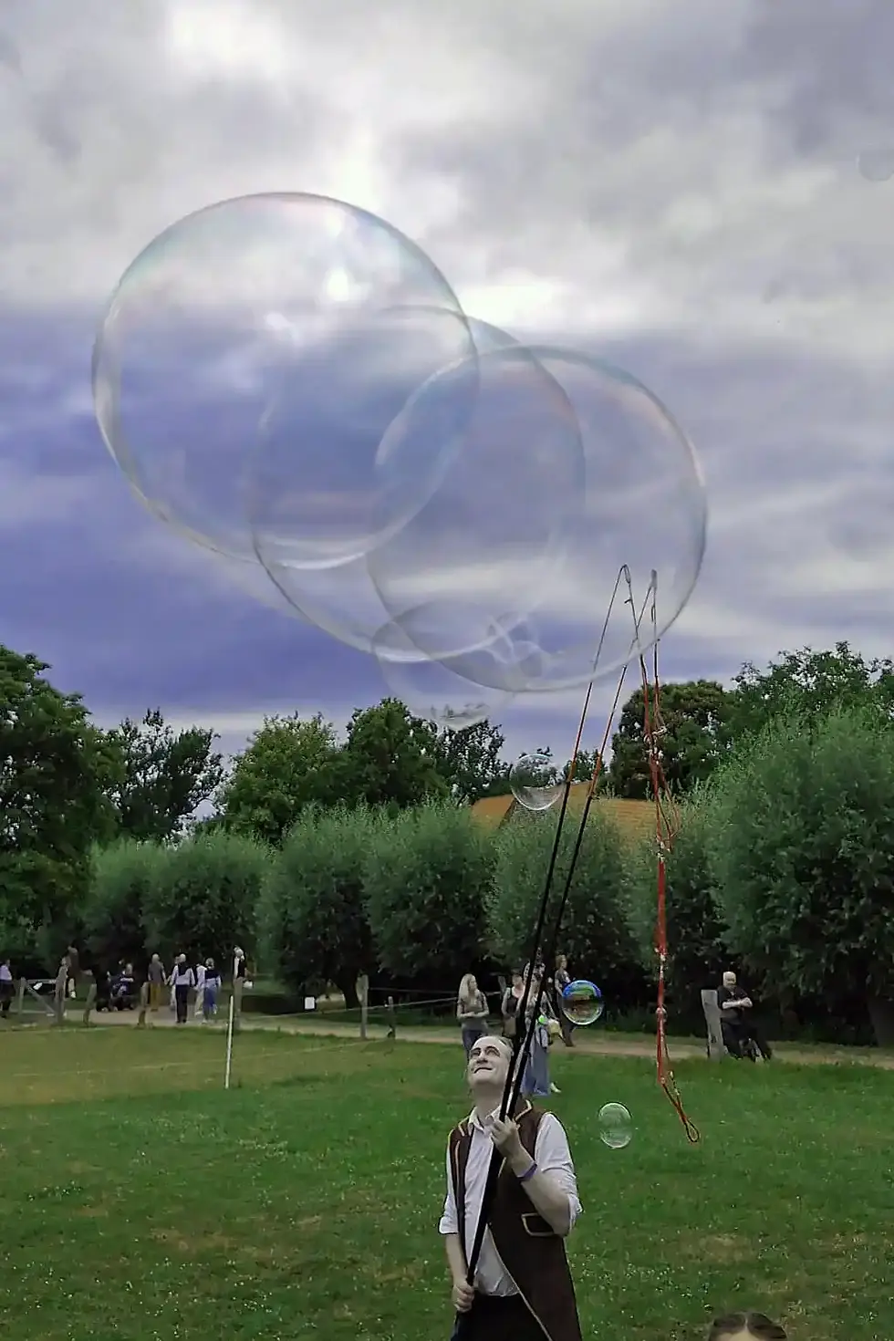 Spectacle de bulles de savon géantes dans un parc.