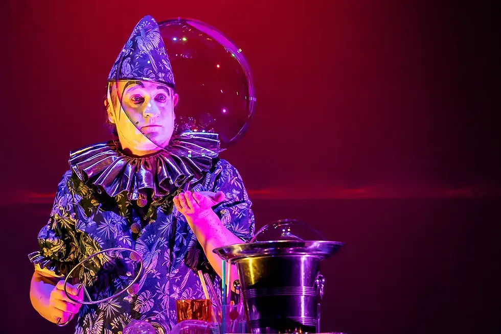 Stephan Masur, magicien en costume bleu, créant des bulles