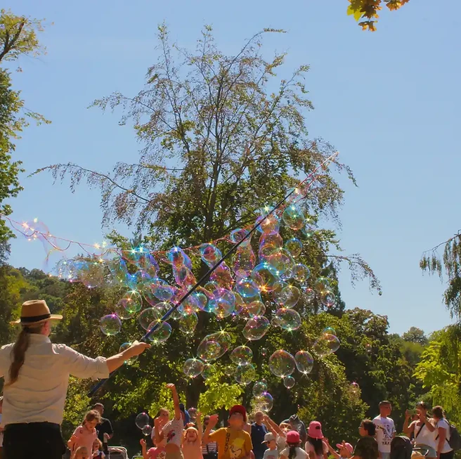 Artiste créant un spectacle de bulles grand est en plein air