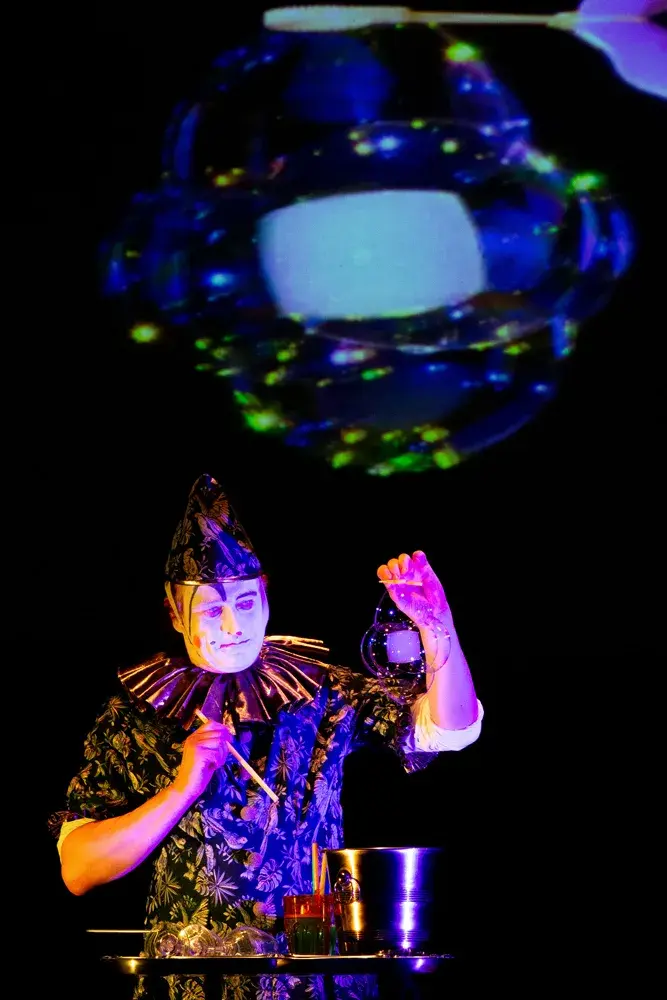 Artiste créant un spectacle de bulles grand est lumineux.