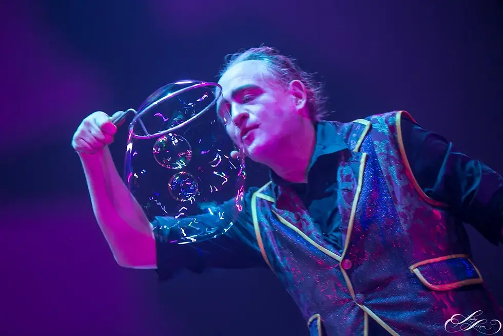 Artiste de spectacle bulles de savon géantes sur scène.