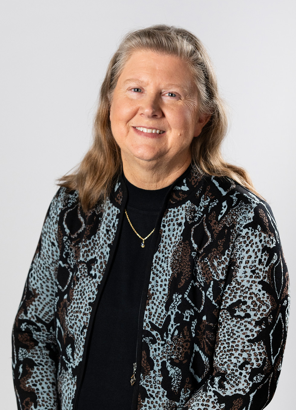 Smiling woman with long hair in patterned jacket