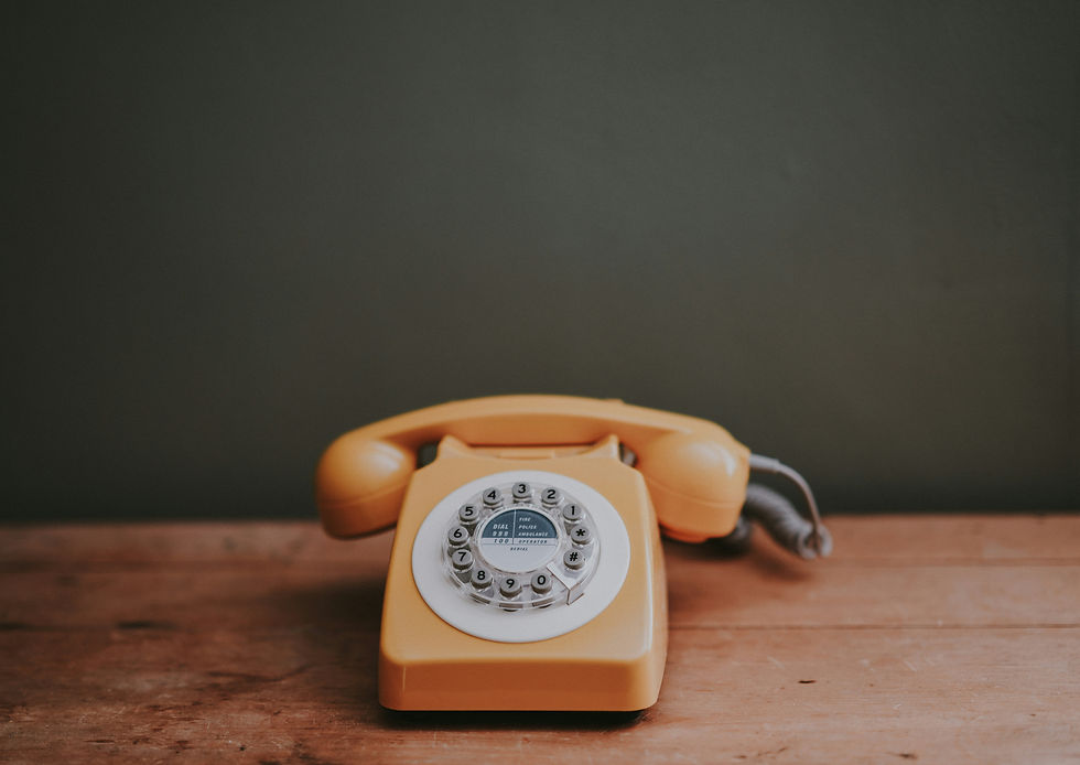 Yellow vintage phone on a neutral background, portrait orientation.