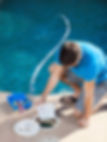 Professional pool maintenance technician cleaning and balancing chemicals