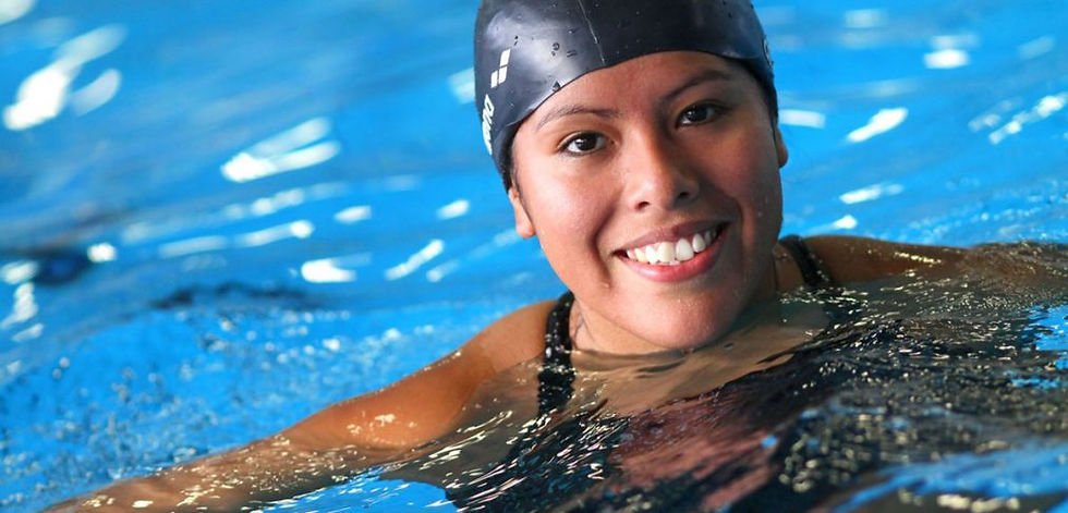 Professional swimming lesson instructor teaching woman proper technique in pool
