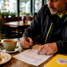 Man reviewing bike repair pricing checklist at home