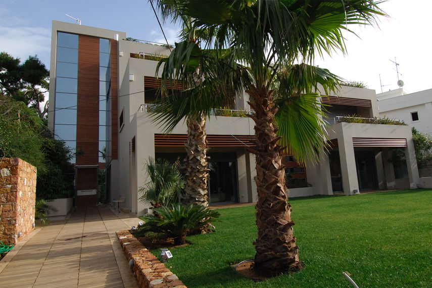 big private residence facade with palm trees and big lawn garden