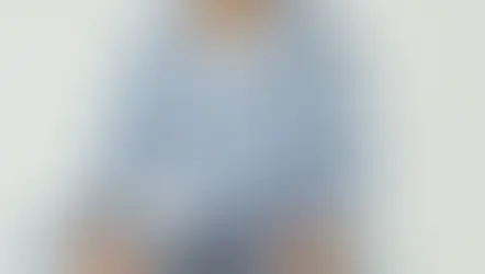 Cropped view of woman in denim shirt holding smartphone and card.