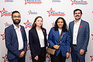 Four students standing in front of PrimeTime signage