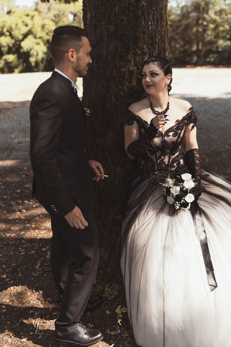 Ritratto di Cinzia e Jonathan con abiti coordinati in nero e avorio nel parco di Villa Lazzari