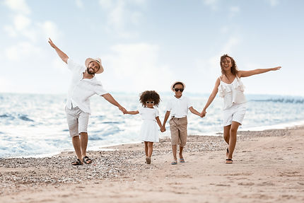 Family of four having fun walking on the beach