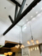 Modern great room with high ceilings and black wood beams.