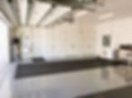 Clean residential garage with glossy flooring and storage.