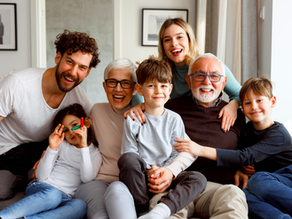 A happy family with aging parents, smiling together on a large couch