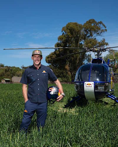 Aaron Fitzgerald standing in a field beside the Red Bull BO-105