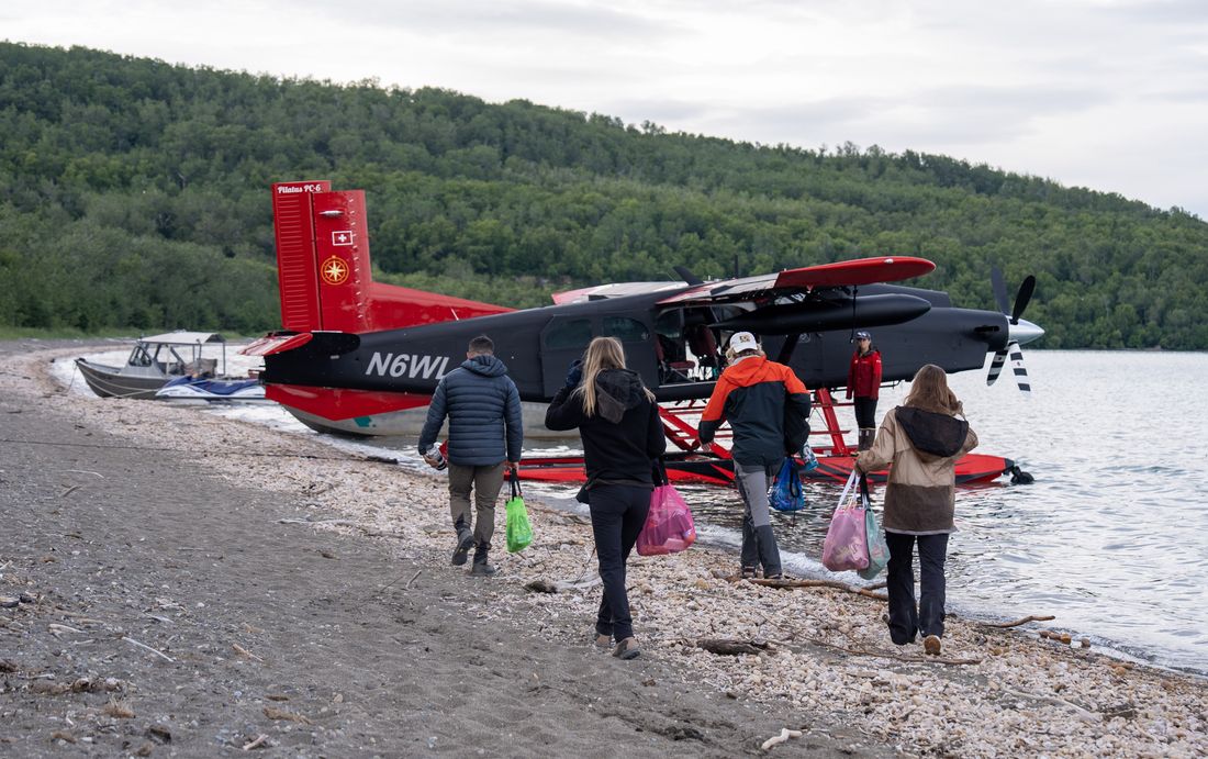 A group gathered by a floatplane on an Alaskan beach