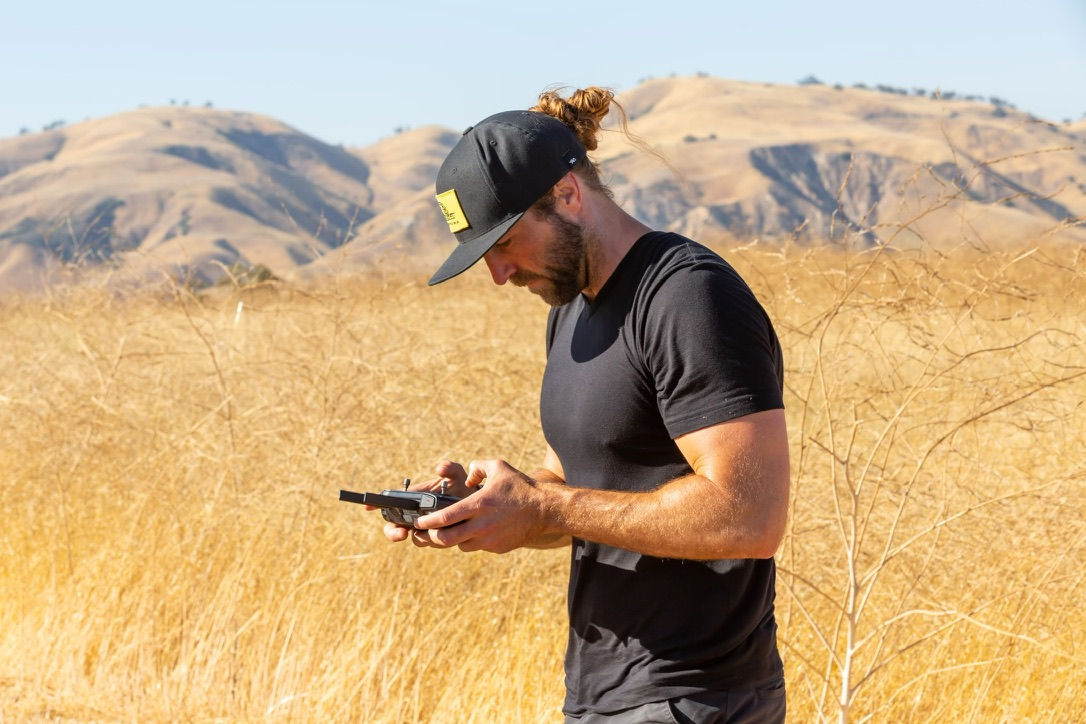A pilot with a controller in a golden field