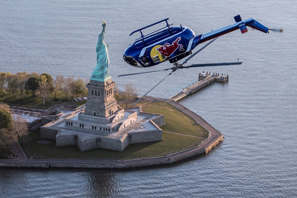 The Red Bull BO-105 flying past the Statue of Liberty