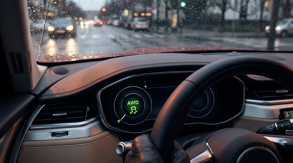 Driver's gloved hand on a steering wheel in rainy traffic. Dashboard shows "AWD" icon. Raindrops on windshield, city lights in background.