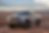 Silver truck on rocky desert terrain, under a blue sky with clouds. Bold grille and headlights prominent. Text: "Toyota Tacoma". Rugged mood.
