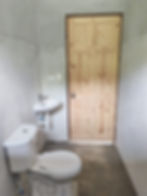Construcción y remodelación de baño con puerta de madera.