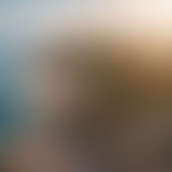 Best wedding venues in Costa Brava by Casamiga Weddings: Aerial view of a coastal villa with a pool, surrounded by lush trees. Adjacent beach and ocean under a golden sunset, creating a serene mood.