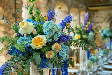 Blue and yellow wedding floral centerpiece at Convent de Blanes reception, Blanes, Costa Brava Spain
