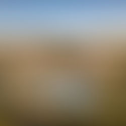 Destination Wedding in Spain Cost 2026: Budget Guide by Casamiga Weddings. Stone villa with red-tiled roofs, surrounded by lush greenery. Central pool with lounge chairs. Clear blue sky and distant hills. Luxurious and serene.