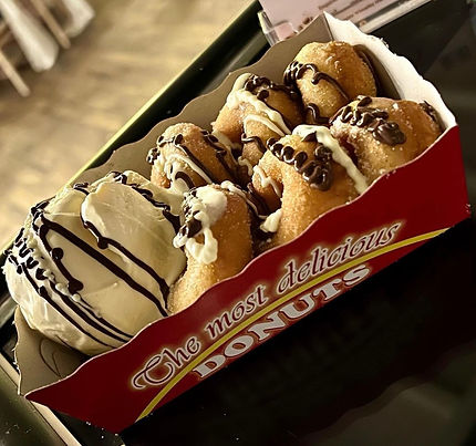 Freshley made donuts in a tray with topping sauces and ice cream.