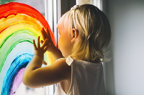 Little girl hands touch painting rainbow