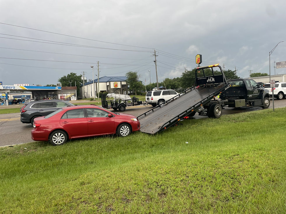 A red car being prepared to be loaded onto a tow truck.